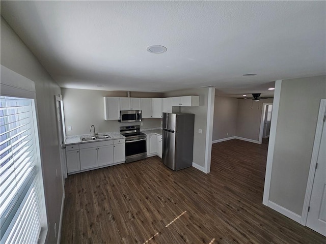 kitchen with white cabinetry, stainless steel appliances, dark wood-type flooring, and sink