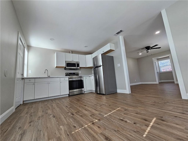 kitchen with white cabinetry, sink, hardwood / wood-style floors, and appliances with stainless steel finishes