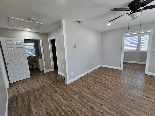 unfurnished room featuring ceiling fan, a wealth of natural light, and dark hardwood / wood-style flooring