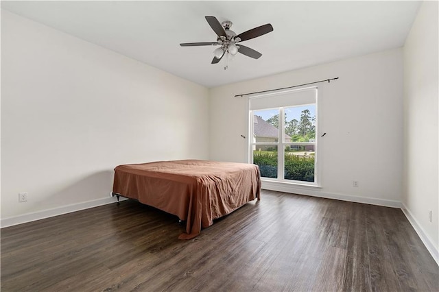 bedroom featuring baseboards, ceiling fan, and dark wood-type flooring