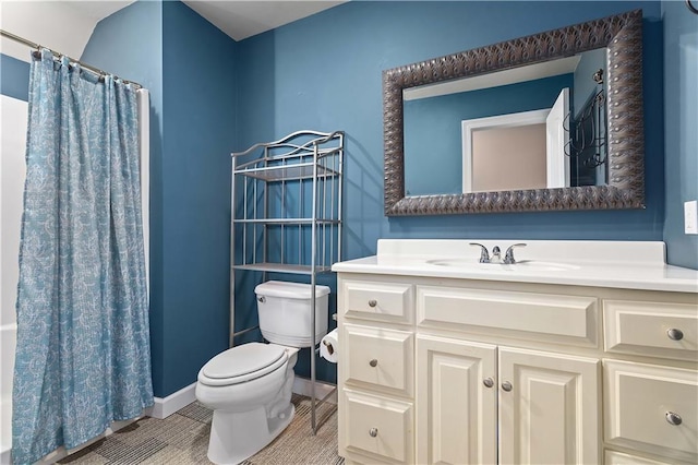 bathroom featuring a shower with curtain, vanity, baseboards, tile patterned floors, and toilet