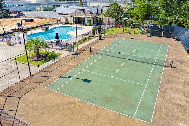 view of sport court featuring a community pool, fence, and playground community