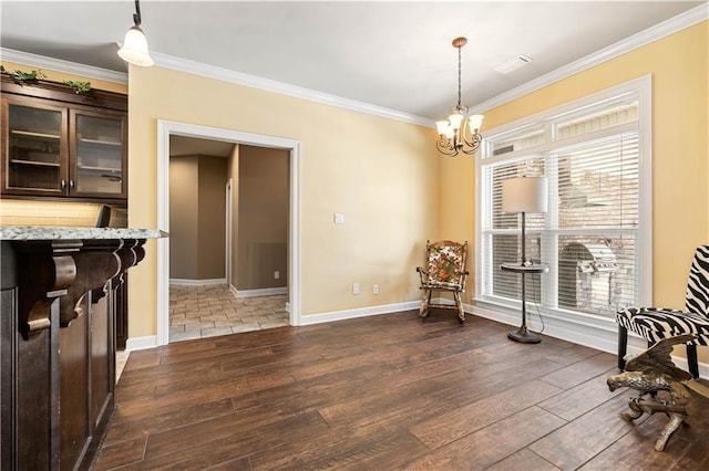 living area featuring an inviting chandelier, ornamental molding, dark wood-style flooring, and a healthy amount of sunlight