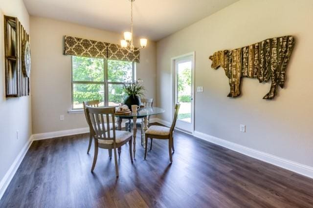 dining area with dark hardwood / wood-style flooring and a chandelier