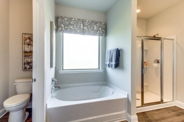 bathroom featuring toilet, hardwood / wood-style floors, and shower with separate bathtub