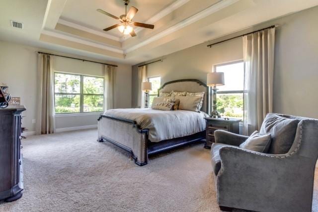 carpeted bedroom featuring crown molding, ceiling fan, and a tray ceiling