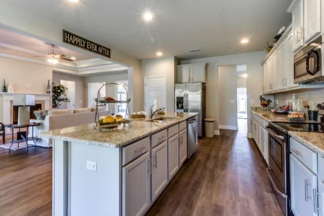 kitchen featuring appliances with stainless steel finishes, dark hardwood / wood-style flooring, a kitchen island with sink, and a wealth of natural light