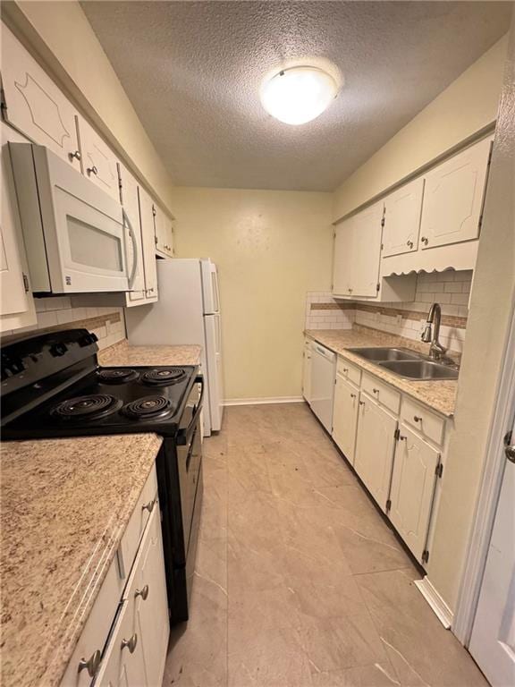 kitchen with tasteful backsplash, white appliances, sink, and a textured ceiling