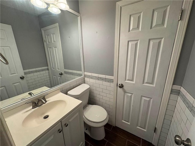 bathroom with vanity, tile walls, and toilet