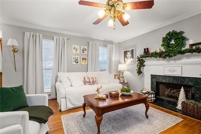 living room with light hardwood / wood-style floors, a wealth of natural light, ornamental molding, and a premium fireplace