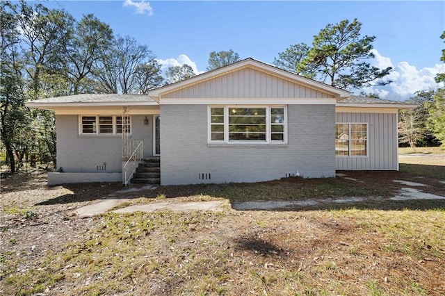 view of front of property with crawl space and brick siding