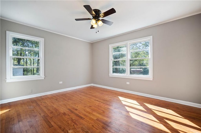 unfurnished room featuring ceiling fan, baseboards, crown molding, and wood finished floors