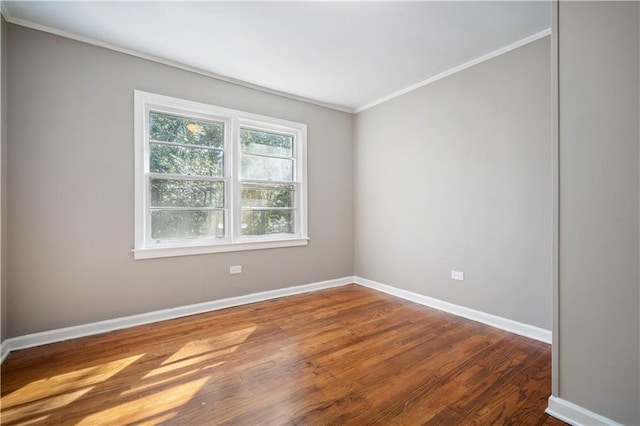 unfurnished room featuring ornamental molding, baseboards, and wood finished floors