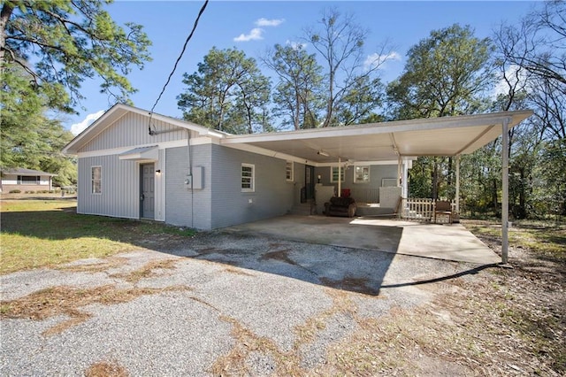 back of property with a lawn, aphalt driveway, a carport, and brick siding