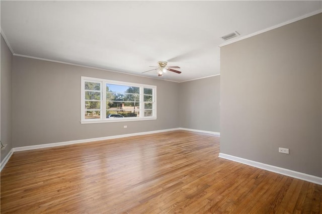 unfurnished room featuring light wood-style flooring, a ceiling fan, visible vents, baseboards, and ornamental molding