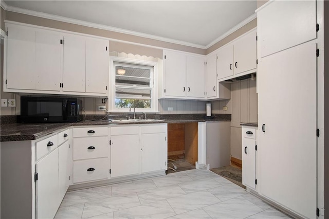 kitchen featuring black microwave, a sink, white cabinetry, marble finish floor, and crown molding