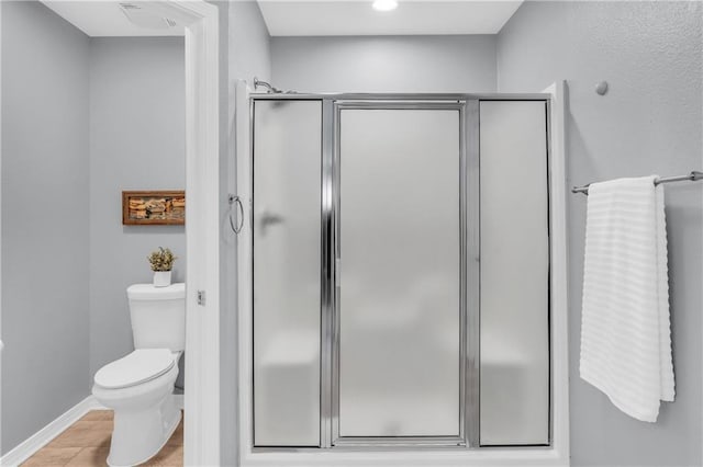 full bath with a shower stall, toilet, visible vents, and baseboards