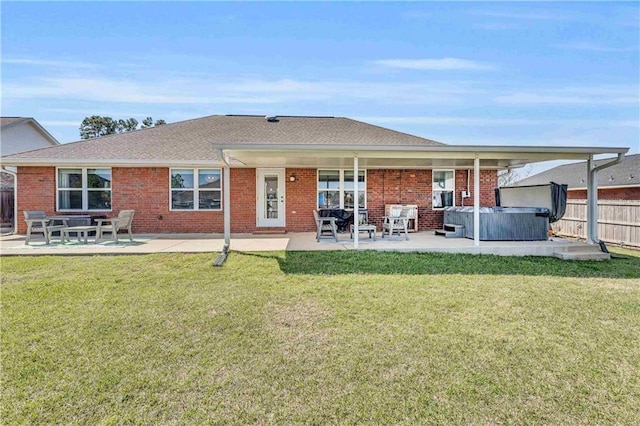 back of house featuring a patio area, a hot tub, a yard, and fence