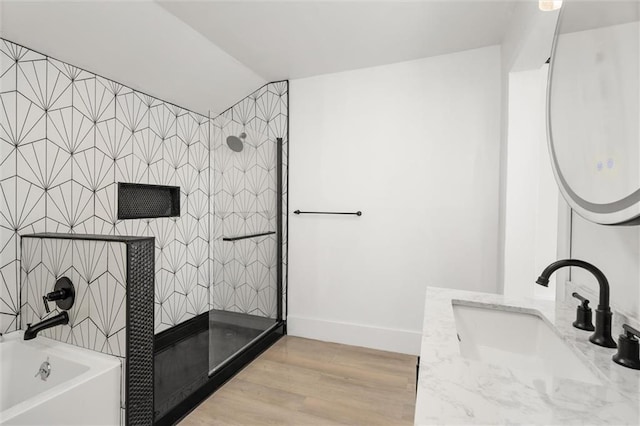 bathroom featuring plus walk in shower, vanity, and hardwood / wood-style flooring