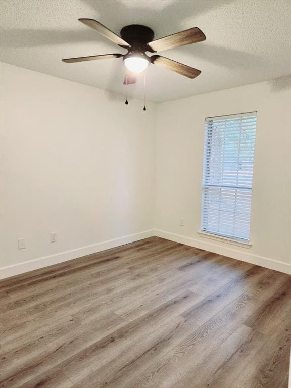 empty room featuring hardwood / wood-style floors, a textured ceiling, and ceiling fan