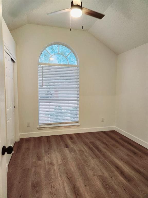 unfurnished room featuring vaulted ceiling, dark wood-type flooring, and ceiling fan