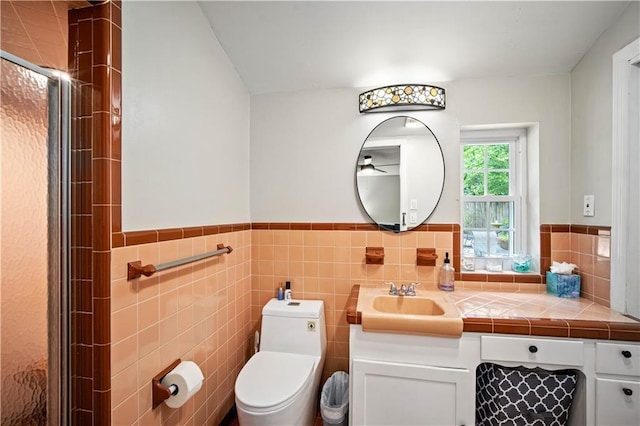 361 Tatum Ave, Mobile, AL 36609 - bathroom featuring a ceiling fan, vanity, a stall shower, a wainscoted wall, and tile walls