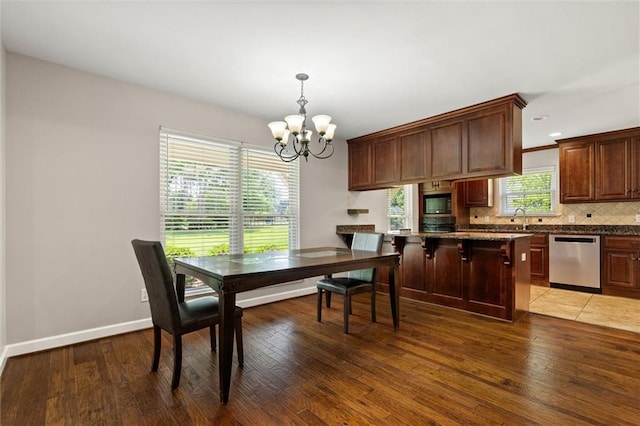 9100 Johnson Rd S, Mobile, AL 36695 - dining space with a chandelier, light wood-type flooring, and baseboards