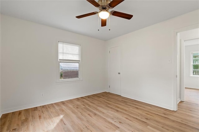 spare room featuring a wealth of natural light, ceiling fan, and light wood-type flooring