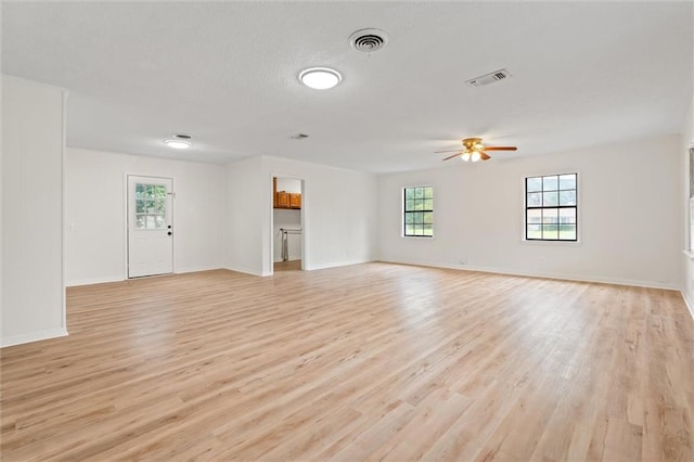 unfurnished living room featuring ceiling fan, light wood-type flooring, and a textured ceiling