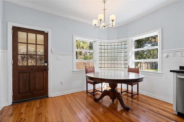 dining area with a wealth of natural light, ornamental molding, and wood finished floors