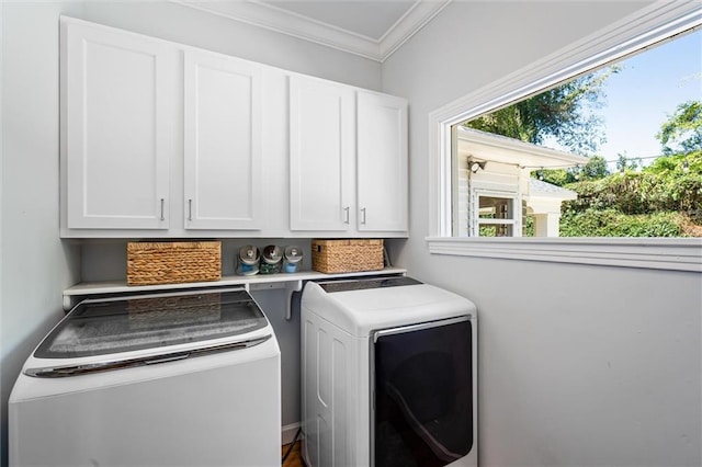 laundry area featuring cabinet space, washing machine and dryer, and crown molding