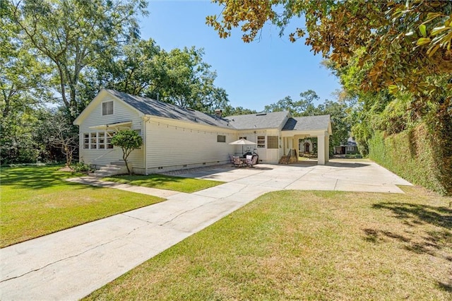 rear view of house with entry steps, crawl space, a patio, and a lawn