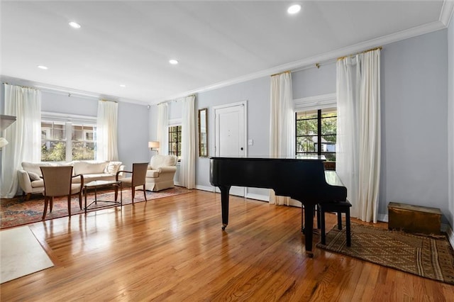 sitting room featuring baseboards, ornamental molding, recessed lighting, and light wood-style floors