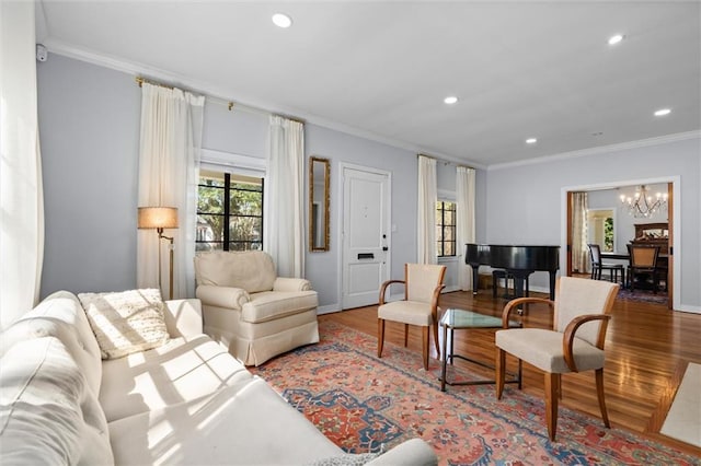 living area with a chandelier, recessed lighting, crown molding, and wood finished floors