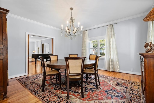 dining area with light wood-style floors, baseboards, and crown molding