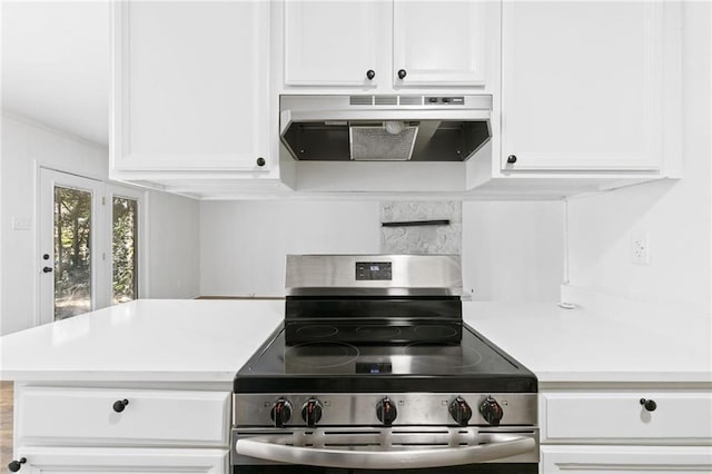 kitchen with stainless steel electric range and white cabinetry