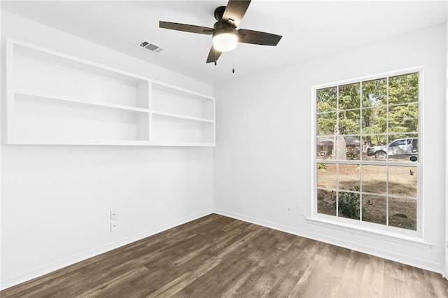 empty room with ceiling fan and dark wood-type flooring