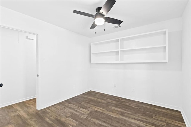 spare room featuring dark hardwood / wood-style flooring and ceiling fan