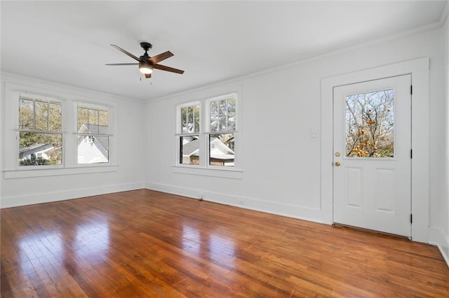 interior space featuring a wealth of natural light, ornamental molding, and wood finished floors