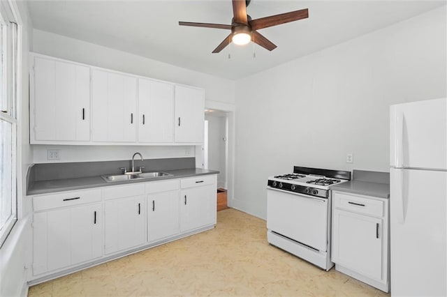 kitchen featuring light floors, white appliances, white cabinetry, a ceiling fan, and a sink