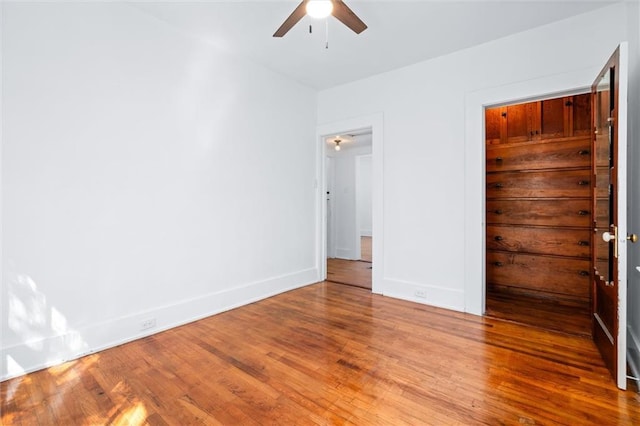 unfurnished bedroom featuring a ceiling fan, baseboards, and wood finished floors