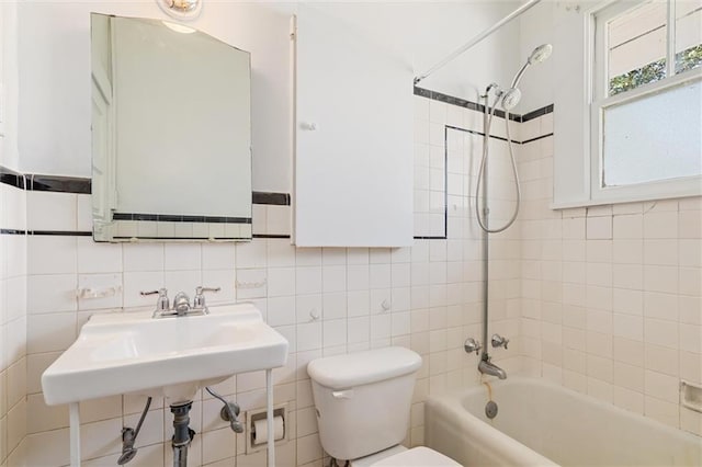 bathroom featuring tile walls, toilet, and shower / tub combination