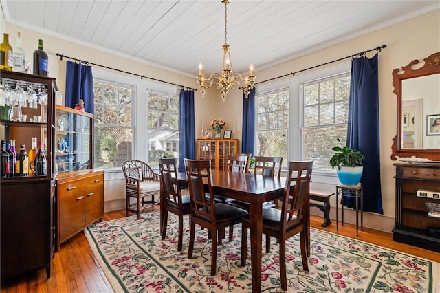 dining room with wood ceiling, an inviting chandelier, hardwood / wood-style floors, and crown molding