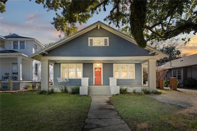 bungalow-style home featuring a porch and a yard