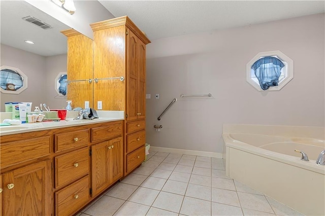 bathroom featuring vanity, tile patterned floors, and a bath