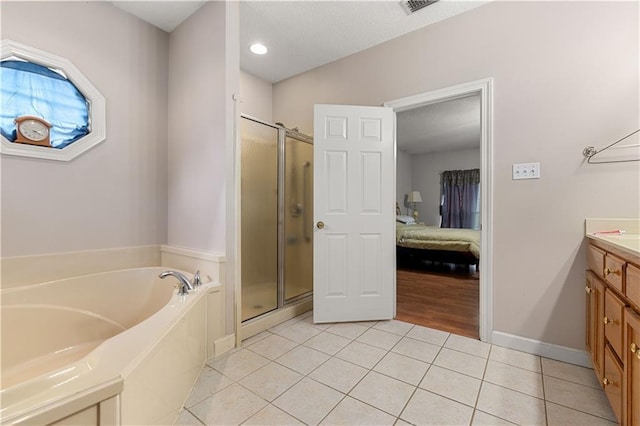 bathroom with vanity, tile patterned floors, and plus walk in shower