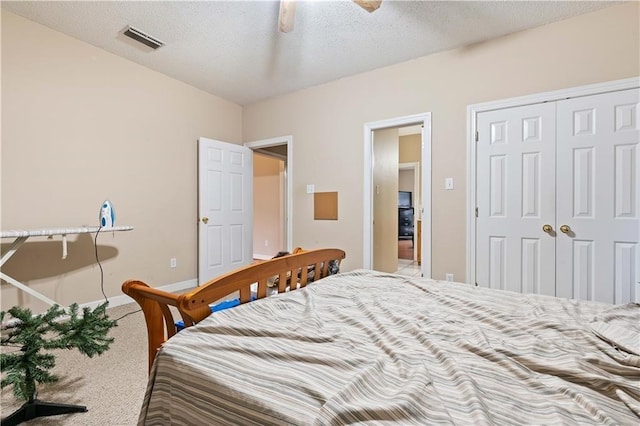 bedroom featuring a textured ceiling, carpet floors, a closet, and ceiling fan