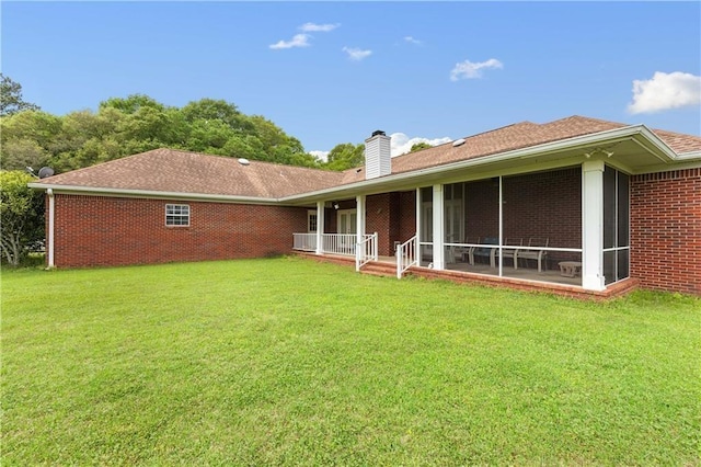 back of house featuring a yard and a sunroom