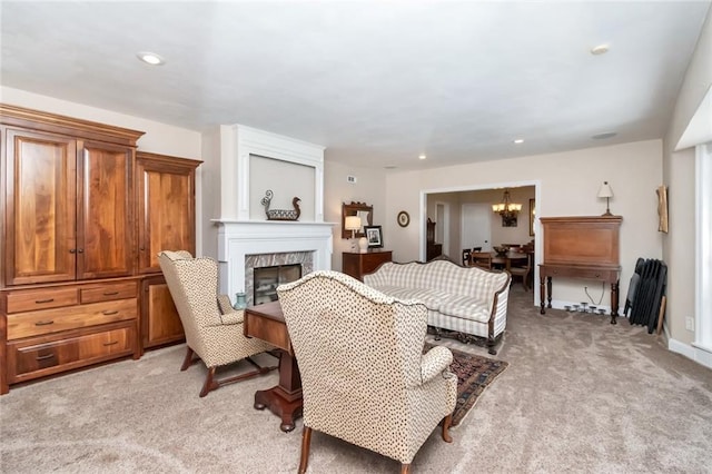 carpeted living room featuring a large fireplace and a chandelier