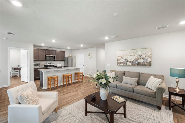 10232 Brodick Loop, Spanish Fort, AL 36527 - living room featuring light wood finished floors, recessed lighting, and baseboards